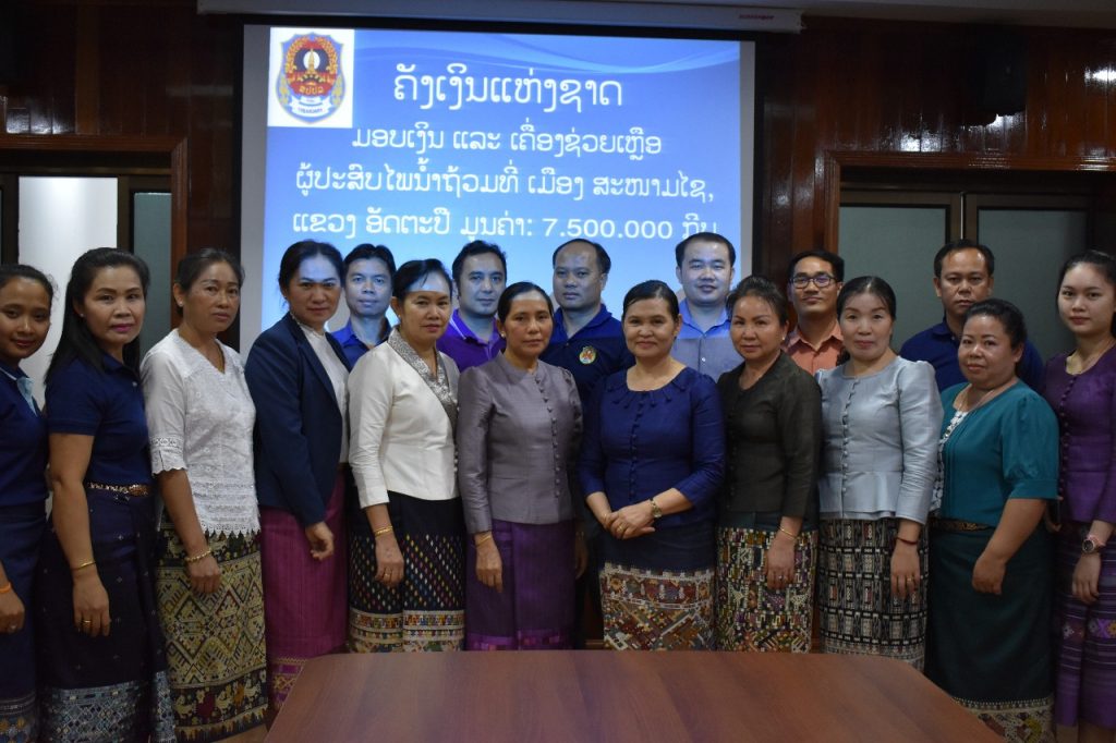 ຄັງເງິນແຫ່ງຊາດ ມອບເງິນ ແລະ ເຄື່ອງຊ່ວຍເຫຼືອໃຫ້ຜູ້ປະສົບໄພນ້ຳຖ້ວມ ທີ່ເມືອງສະໜາມໄຊ ແຂວງອັດຕະປື ມູນຄ່າ 7,500,000 ກີບ